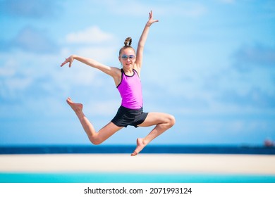Happy girl jumping at tropical beach having a lot of fun on summer vacation