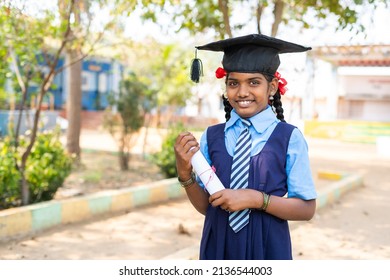 Happy Girl Kid In Uniform Standing By Dreaming About Graduation While Holding Graduation Certificate At School - Concept Of Future Career, Education And Development.