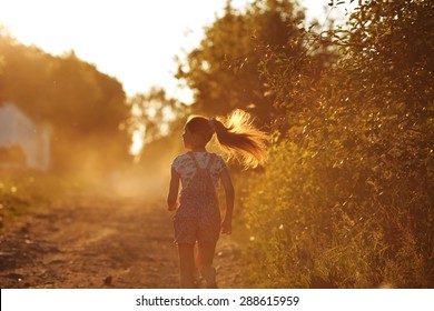 Happy girl with long hair running down a country road - Shutterstock ID 288615959