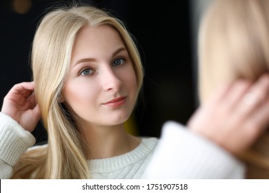 Happy girl looks in mirror her eyebrows   face  Color gradient at eyebrow from light to dark  Gentle   natural decorative makeup  Effect fashionable thick  wide   lush eyebrows