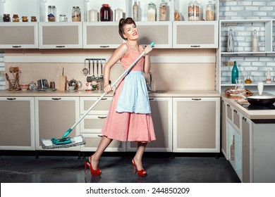 Happy Girl Makes Cleaning The Kitchen, Hands Holding A Mop While Singing.