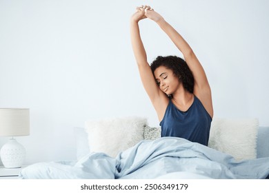 Happy girl, morning stretching and wake up in home bedroom after sleeping or rest. Relax, peace and comfort of African woman smiling with wellness and feeling fresh, awake and well rested in house - Powered by Shutterstock