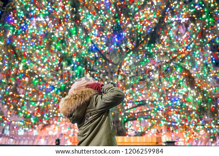 Happy girl on the background of the Rockefeller Christmas tree in New York. Beautiful Christmas Tree at Rockefeller center