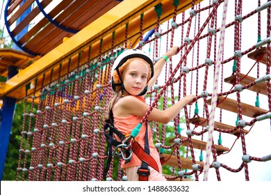 Happy Girl On Rope Way In Amusement Center For Children.