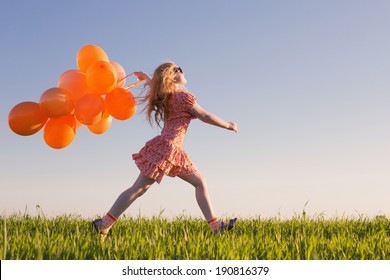 happy girl with orange balloons outdoor