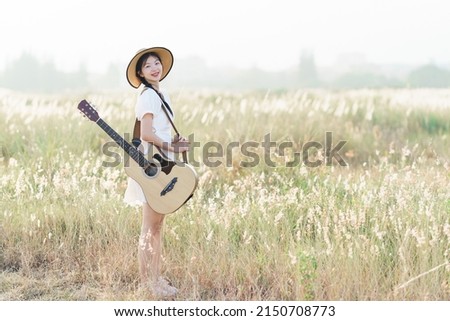 happy girl playing guitar at park