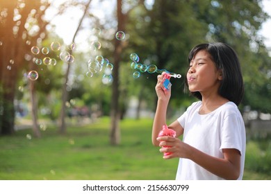 Happy girl playing with soap bubbles. Active child walking in the park. Family lifestyle. holiday kid concept