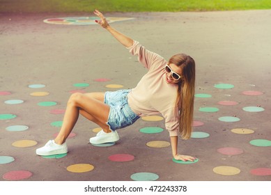 Happy girl playing twister game outdoor