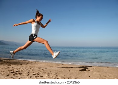 Happy girl running alone on the beach