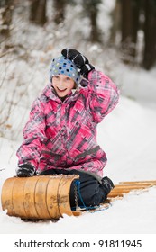 Happy Girl Sledding On An Old Wooden Toboggan In Winter