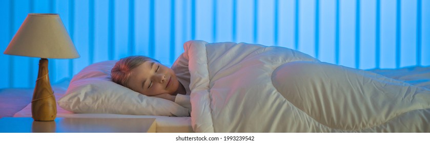 Das glückliche Mädchen, das auf dem Bett schläft. Abendnachtszeit