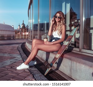 happy girl smiles, laughs, talks on cell phone, cup coffee tea, free space text, weekend break, snack, fun conversation online app Internet, skateboard long board. Resting, tanned figure beautiful - Powered by Shutterstock