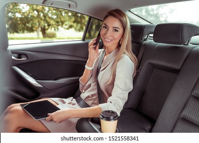 Happy Girl Smiling, Beautiful Business Lady Woman, Rides Taxi Car Salon, Mobile Phone Call, Tablet, Cup Coffee Tea, Goes To Work Important Meeting. Concept Of Calm And Relaxation In Business VIP Taxi