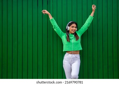 Happy Girl Smiling With Mobile Phone And Earphones In The Street Dancing