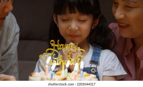 Happy Girl Surrounded By Family Making Wish And Blowing Out Candles On Birthday Cake Close Up Shot, Cheerful Little Kid Celebrating Birthday Party With Family At Home, Birthday Party For Kids