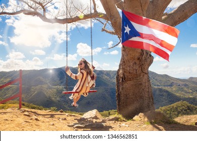 Happy girl swinging from tree over mountain landscape at Curva Del Arbol in Cayey Puerto Rico