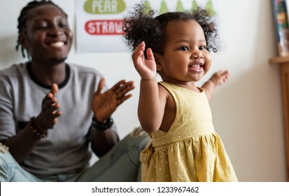 Happy girl and teacher having fun in nursery