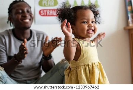 Happy girl and teacher having fun in nursery