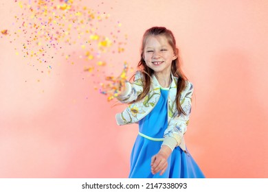 Happy Girl Throwing Confetti Against Pink Background At Party - Sparkle Glitter At A Family Festival