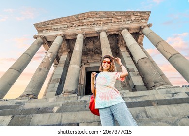 A Happy Girl Traveler Admires The Ancient Hellenic And Greek Or Roman Architecture Standing On The Stairs At The Old Temple