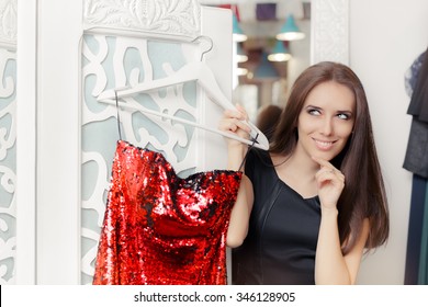 Happy Girl Trying on Red Party Dress in Dressing Room - Smiling fashion holding a clothes hanger with a fashionable garment 