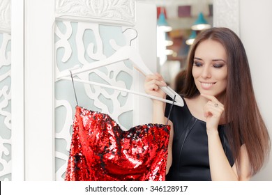 Happy Girl Trying on Red Party Dress in Dressing Room - Smiling fashion holding a clothes hanger with a fashionable garment 