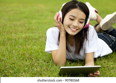 happy girl using tablet pc on the grass - Powered by Shutterstock