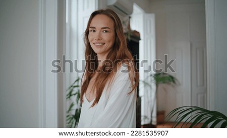 Happy girl walking at morning flat closeup. Smiling woman spinning at luxury apartment portrait. Lovely lady looking camera moving at home. Beautiful female person enjoying leisure time at cozy house