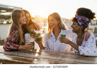 Happy girls having fun drinking cocktails at bar on the beach - Soft focus on center blond girl face - Powered by Shutterstock