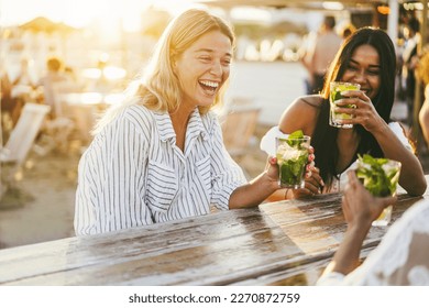 Happy girls having fun drinking cocktails at bar on the beach - Soft focus on left girl face - Powered by Shutterstock