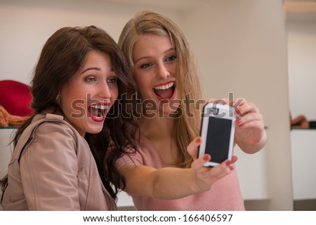 Similar – Two women laughing looking at their smart phone