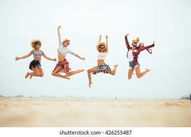 Happy Girls Jumping On The Beach.