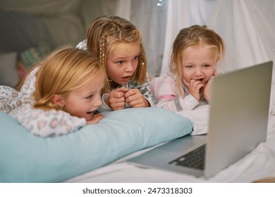 Happy, girls and laptop for streaming tv or watching movies before bedtime for relax and comfort. Exited, sisters or friends and computer for bonding with entertainment and film in blanket fort - Powered by Shutterstock