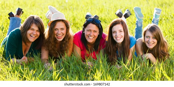 Happy girls laying on grass laughing together - groupphoto series. - Shutterstock ID 169807142