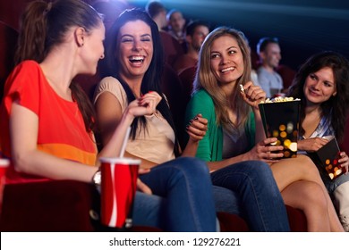 Happy girls sitting in multiplex movie theater, talking, laughing. - Powered by Shutterstock