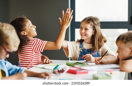 Happy  girls students schoolkids celebrate together  successful completion of collective school work in a light classroom - Powered by Shutterstock