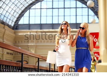Happy girls with sunglasses taking photos with a smartphone 
