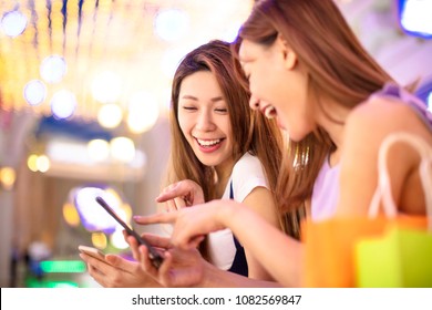 Happy Girls Using Smart Phone In The Shopping Mall