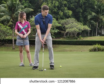 Happy Golf Couple Playing On Green Together, Sport Concept.