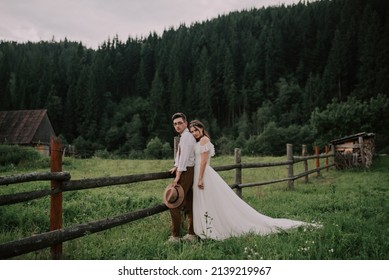 Happy gorgeous bride and groom walking holding hands, boho style wedding couple, gorgeous couple in the mountains with amazing scenery, space for text