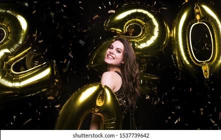 Happy Gorgeous Girl In Stylish Sexy Party Dress Holding Gold 2020 Balloons, Having Fun At New Year's Eve Party.