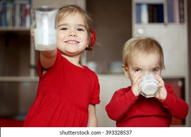 Happy Gorgeous Little Girl With Milk Mustache Showing An Empty Glass While Her Little Cute Brother Drinking A Glass Of Milk At Home, Food And Drink Concept, Healthy Food, Indoor