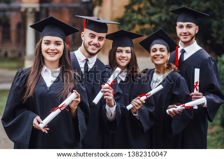 Happy graduates. Five college graduates standing in a row and smiling. Nice time!