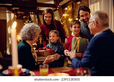 Happy grandchildren giving their grandparents presents on Christmas Eve at home. - Powered by Shutterstock