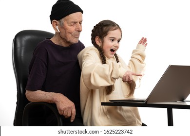 Happy Granddaughter Wearing Beige Hoodie Play By Laptop With Her Stylish Grandfather In Black Hat And T-shirt, Spending Time Togather, Isolated Over White Background, Studio Photo