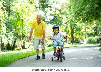 Happy Grandfather And Child Have Fun And Play In Park On Beautiful  Sunny Day