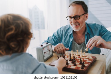 Happy grandfather plays chess with small grandson. Development of logic and strategic thinking. - Powered by Shutterstock