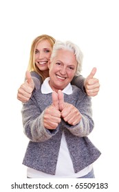 Happy grandma and her granddaughter holding their thumbs up