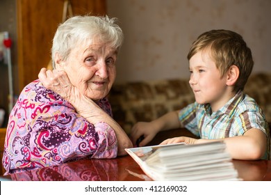 Happy grandma sits with his young grandson.