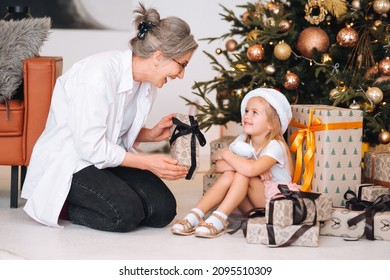 Happy grandmother giving christmas present to excited granddaughter. - Powered by Shutterstock